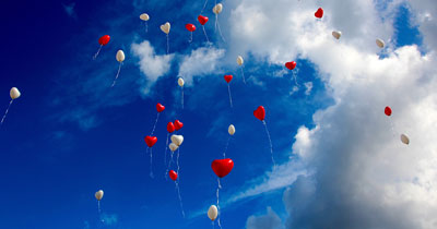 red and white heart shaped balloons in the sky