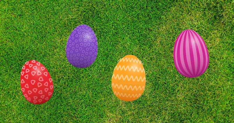 A selection of colourful Easter eggs lying on the grass