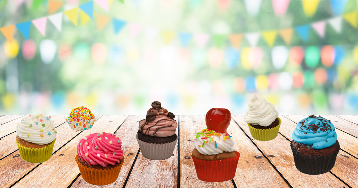 A selection of tempting cupcakes on a table with pastel bunting in the background
